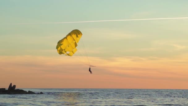 Parasailing is actief type recreatie, persoon op parachute zweeft door de lucht. — Stockvideo