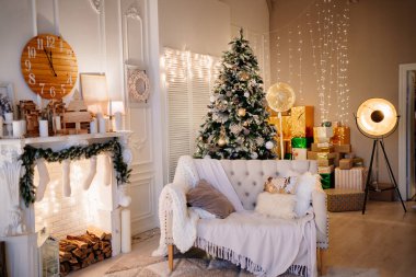 Yeni yıl atmosferi. Yeni yıl için dekore edilmiş şöminenin yanında bir koltuk.. 