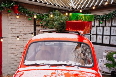 Evin verandasında çatıdan hediyeler olan kırmızı küçük bir araba.. 