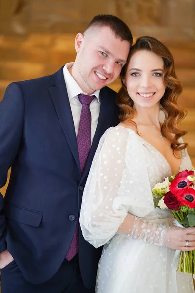 Ein schönes Brautpaar mit einem Strauß. — Stockfoto