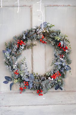 Beyaz kapıda yeni yıl çelengi var. Noel için evi dekore etme geleneği