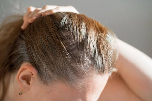La donna mostra le radici cresciute di capelli grigi. vernice per capelli grigi. — Foto Stock
