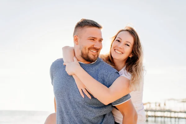 Ένας διασκεδαστικός άντρας και μια ερωτευμένη γυναίκα να αγκαλιάζονται και να διασκεδάζουν στην παραλία. ηλιακή λάμψη — Φωτογραφία Αρχείου