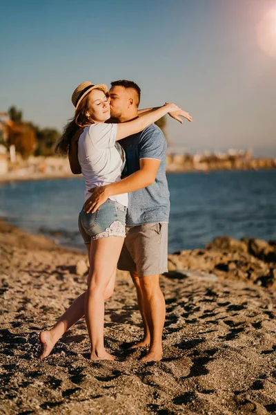 Un uomo e una donna innamorati si abbracciano sulla spiaggia. sposi novelli al resort. sole luminoso. — Foto Stock