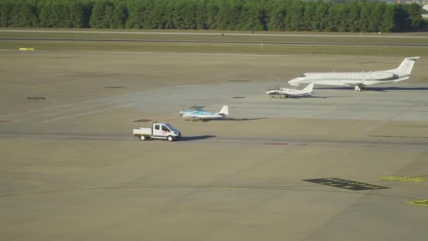 Mobil berjalan dengan pesawat penumpang dari berbagai maskapai di tempat parkir bandara — Stok Video