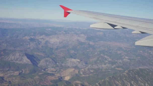 A légi jármű szárnya a légi jármű ablakából menekülve. föld felett. — Stock videók