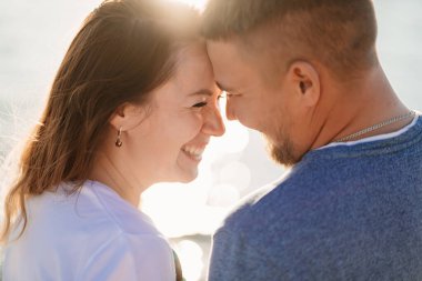 Profiller, aşık çiftlerin deniz sahillerinde eğlendiklerini gösteriyor. Güneş parıltısı