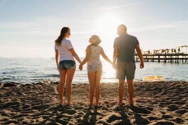 Dikiz aynası. Deniz kıyısında güneş ışığı altında bir aile. Tatil köyünde aile tatilleri.