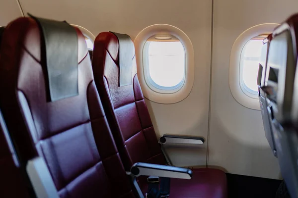 Leere rote Sitze für Passagiere in der Flugzeugkabine. Economy class. — Stockfoto