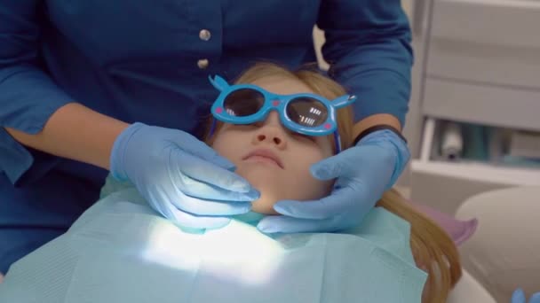 Dentysta bada zęby małej dziewczynki w recepcji.. — Wideo stockowe