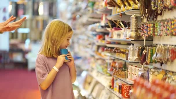 Tidsförskjutning. en mor och dotter ser med intresse souvenirer i butiken. — Stockvideo