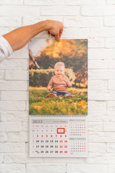 男人手里拿着日历，上面有孩子们的照片。印刷品 — 图库照片