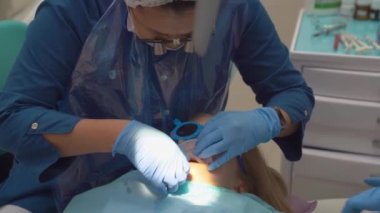 Doktor ağız genişleticiyi küçük bir kızın ağzına koydu.. 