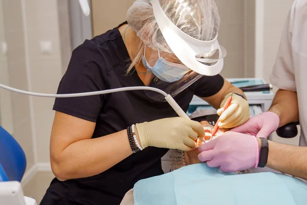 Verkligt. tandläkare borstar tänder patient. regelbunden vård och förebyggande. — Stockfoto