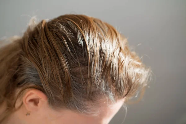 La mujer muestra las raíces crecidas del pelo gris. pintura para el pelo gris. — Foto de Stock
