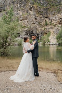 nazik ve sevecen yeni evliler bir dağ gölünün kıyısında.