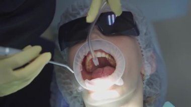 Gerçek. Dişçi hastaların dişlerini fırçalar. düzenli bakım ve önleme.