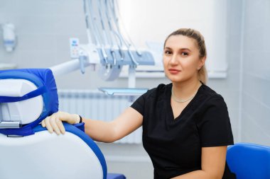 Kliniğin taksisinde iş yerinde siyah üniformalı bir kadın dişçi..