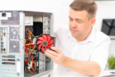 Bilgisayar atölyesi. Tamirci bilgisayara soğutucu yerleştirir