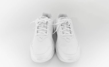 Beyaz arka planda bağcıkları olan beyaz spor ayakkabılar. İzole et. puma