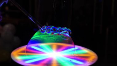 Çok renkli ışıklandırmalı sabun köpüklerinin gösterimi. Karanlıkta güzel bir performans.