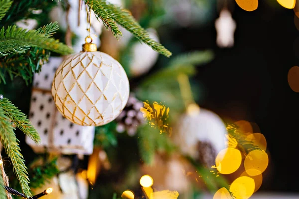 Versierde tak van de kerstboom tegen de achtergrond van gloeilampen van slinger. — Stockfoto