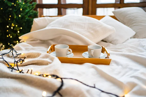 Un plateau en bois pour manger au lit avec deux tasses à thé blanc. — Photo