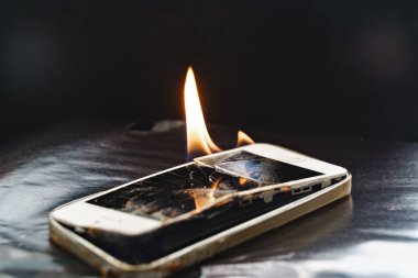 Siyah arkaplanda bozuk akıllı telefon yakmak. 
