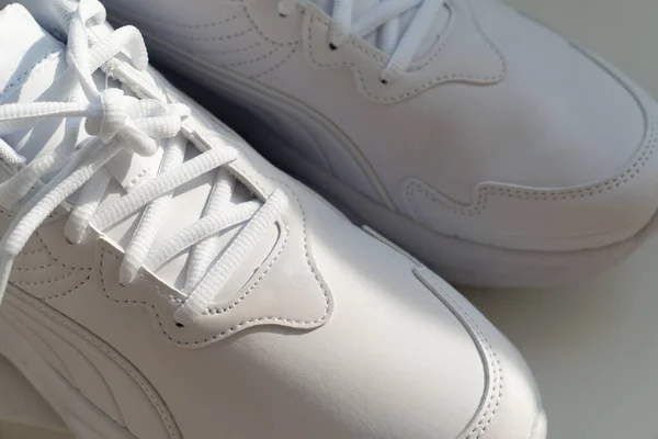 Deel van witte sneakers met veters op een witte achtergrond. — Stockfoto