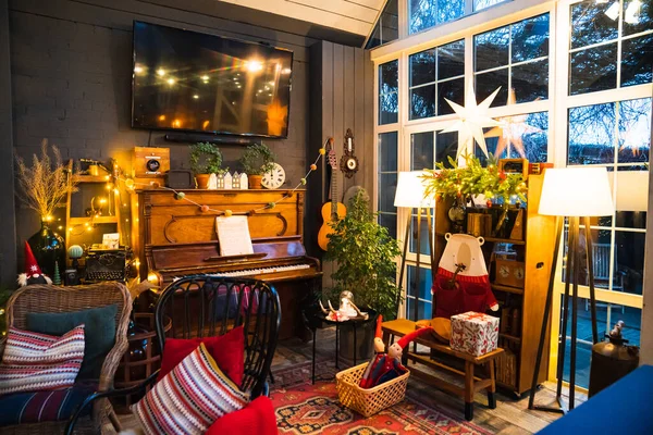Belső tér vintage stílusban retro bútorokkal, zongorával és koszorúkkal este. — Stock Fotó