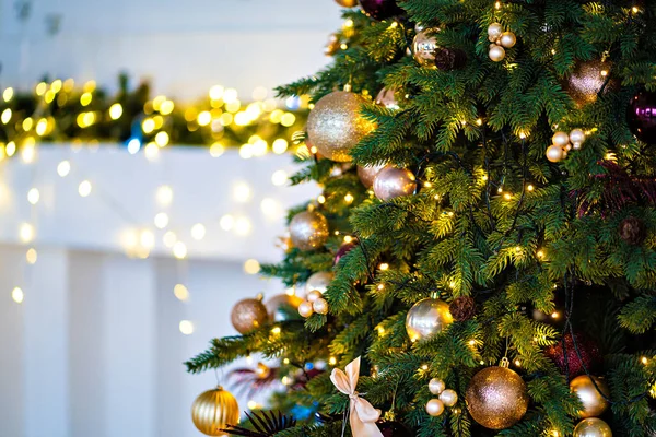 Versierd deel van de kerstboom tegen de achtergrond van gloeilampen van slinger. — Stockfoto