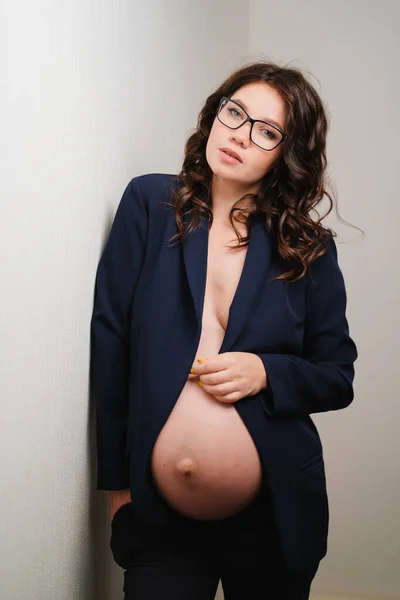 Vacker gravid kvinna i glasögon och svart jacka med bara bröst och mage — Stockfoto