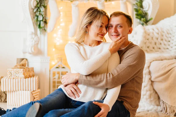 Çekici sarışın bir kadın ve şöminenin yanında kazaklı bir adam..