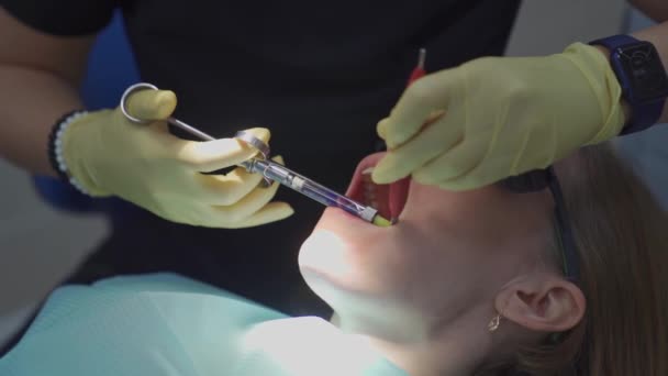 Справжній. стоматолог вводить анестетик у пацієнта перед видаленням зуба — стокове відео