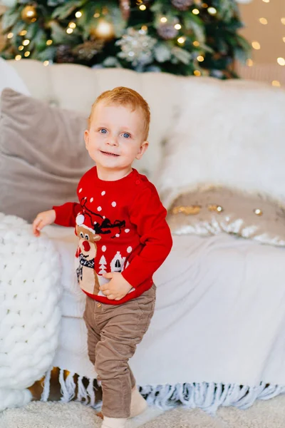 Menino bonito em uma camisola de Natal vermelho. roupas e presentes tradicionais — Fotografia de Stock