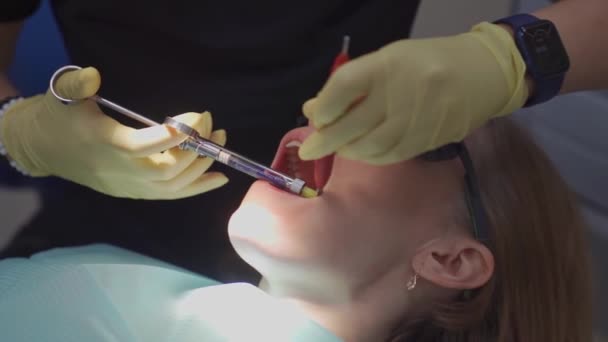 Real. dentista inyecta un anestésico en el paciente antes de la extracción dental — Vídeo de stock