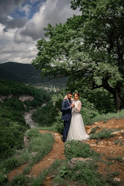 Doux jeunes mariés sur fond de forêt de montagne. mariage en montagne. — Photo