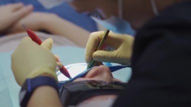 Gerçek. Diş hekimi hastaya bakıcı, diş matkabı ve dolgu malzemesi veriyor.