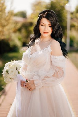 Parktaki patikada bir buket çiçekli esmer gelin..