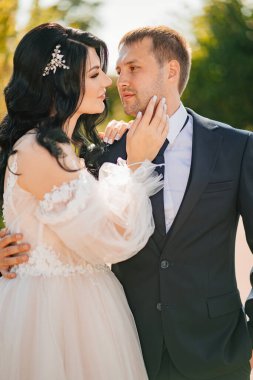 Gelin damadın yanağını nazikçe okşar. Romantik, nazik, sevgi dolu yeni evliler..