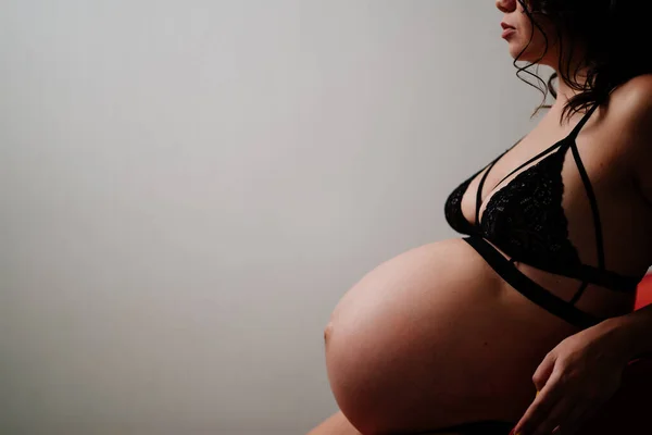 Profil wanita hamil dengan latar belakang dinding. ruang untuk prasasti. — Stok Foto