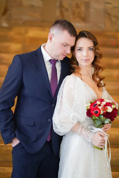 Un beau couple de jeunes mariés avec un bouquet. — Photo