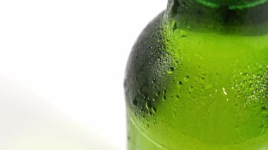 Kapat. Damlalar şişenin soğuk yeşil camından aşağı akar. yoğunlaştır