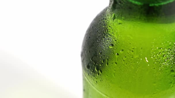 Закрывай. капли стекают по холодному зеленому бокалу бутылки. конденсат — стоковое видео