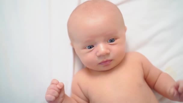 Zicht van bovenaf. schattig baby op een wit laken. — Stockvideo