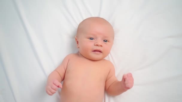 Hände massieren Baby auf weißem Laken für einen gesunden Bauch. — Stockvideo