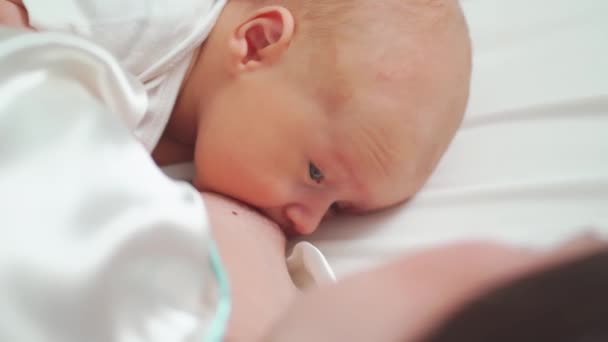 Amamantando. De cerca. madre alimenta al bebé con leche materna acostada en la cama — Vídeo de stock