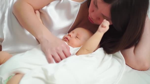 Anya az ágyban fekszik a babával. az anyaság boldogsága. — Stock videók