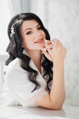 Masada beyaz ipek pijamalı esmer gelin.