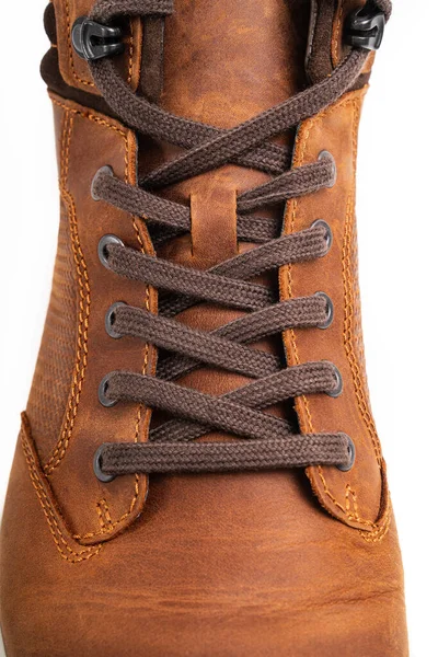 Üst Manzara. Kahverengi deri botların beyaz arka planda bağcıkları var.